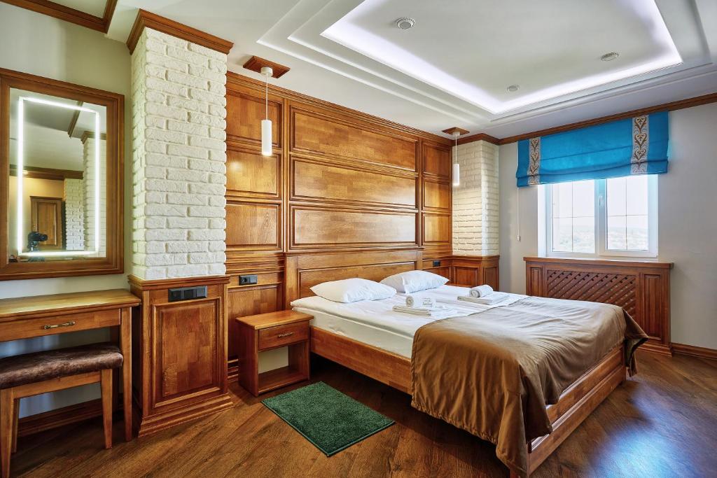 sypialnia z dużym łóżkiem i lustrem w obiekcie Taras Bulba w Kamieńcu Podolskim