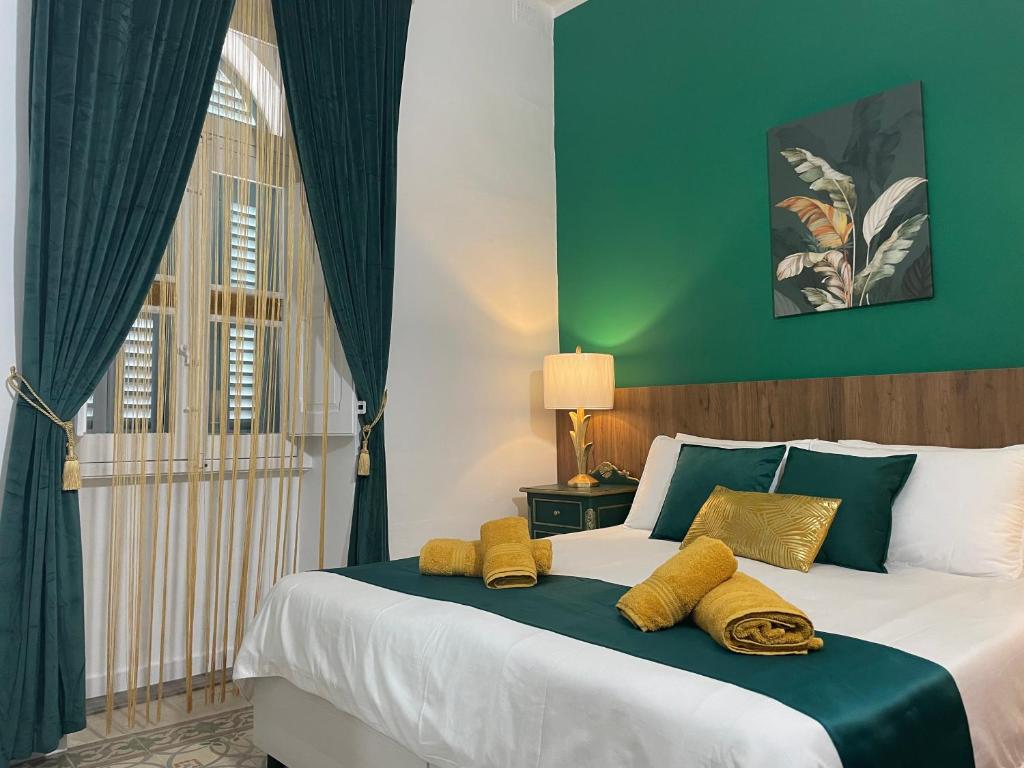 een slaapkamer met een groot bed met gele kussens erop bij Parisio One Bedroom Maisonette in Sliema in Sliema