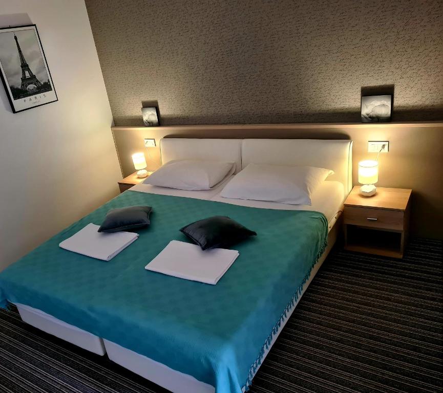 a bedroom with a bed with two pillows on it at BoNiToS, SOBE-ROOMS in Slavonski Brod