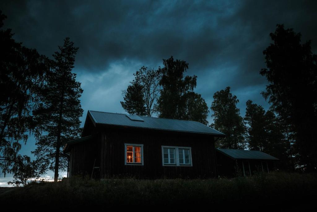 a small house with a light in the window at Off the grid in the abandoned village of Ejheden in Voxnabruk