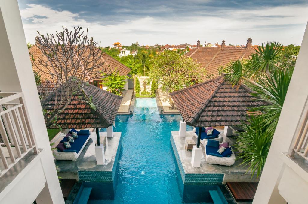 an aerial view of a resort swimming pool with chairs at Villa Andaman in Canggu