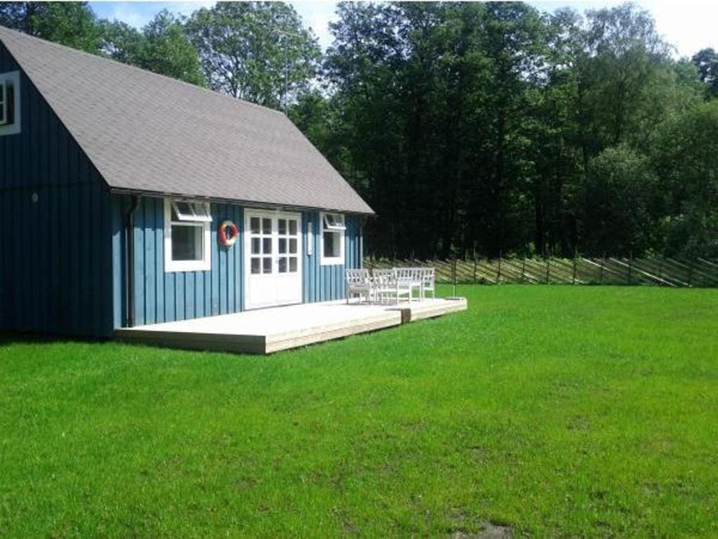 un edificio azul con un porche en un campo en Tirbi Holiday House, en Kassari