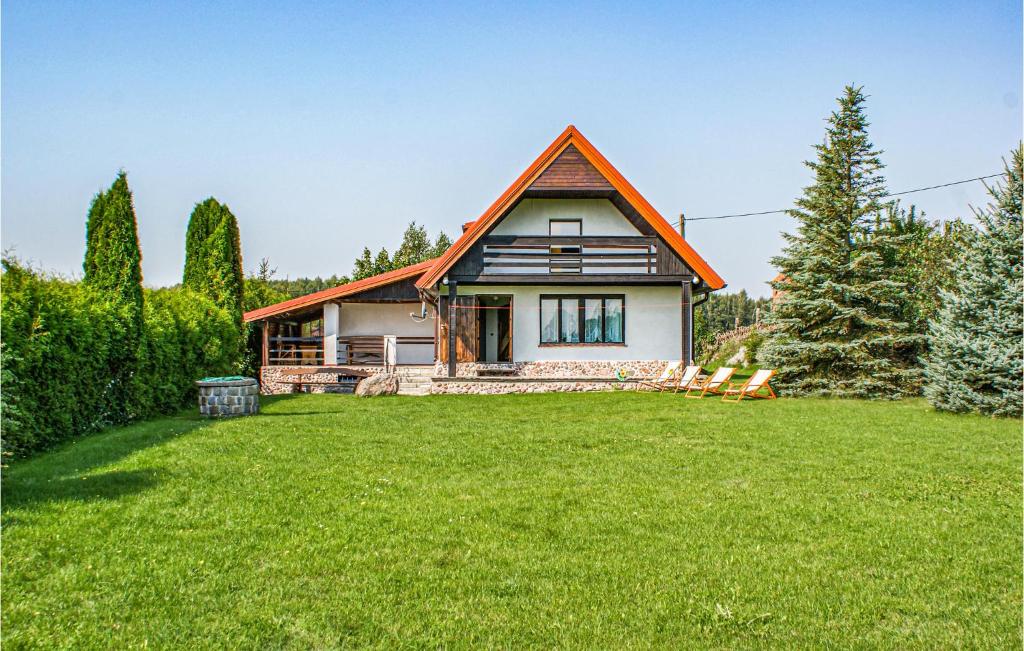 a house with a grass yard in front of it at Stunning Home In Biskupiec With 4 Bedrooms And Wifi in Biesówko