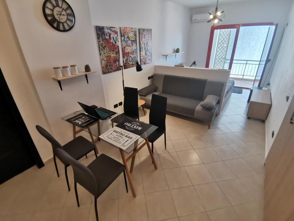 - un salon avec une table, des chaises et un canapé dans l'établissement Art Apartment Clever, à Durrës