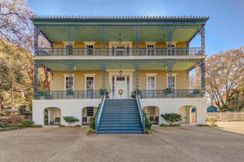 an old house with a staircase leading up to it at The Duff Green Mansion in Vicksburg