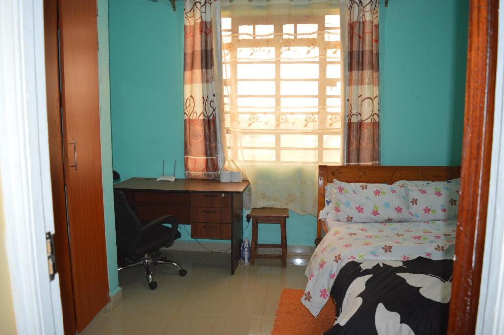 RuiruにあるNikki's place 1BR Thika Road, Ruiruのベッドルーム1室(ベッド1台、デスク、窓付)