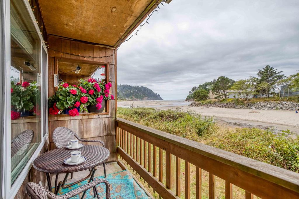 a porch with a table and chairs and a view of the beach at The Dugout #128 in Neskowin