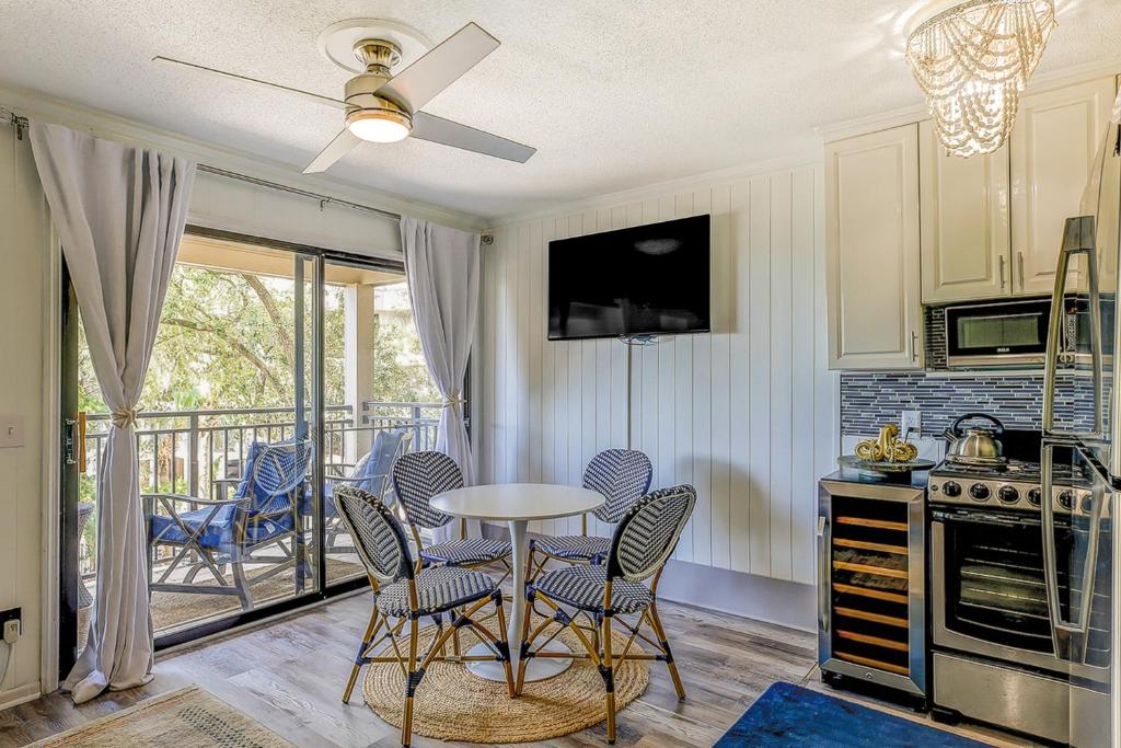 a kitchen with a table and chairs and a balcony at Sea Side Villas 244 in Hilton Head Island