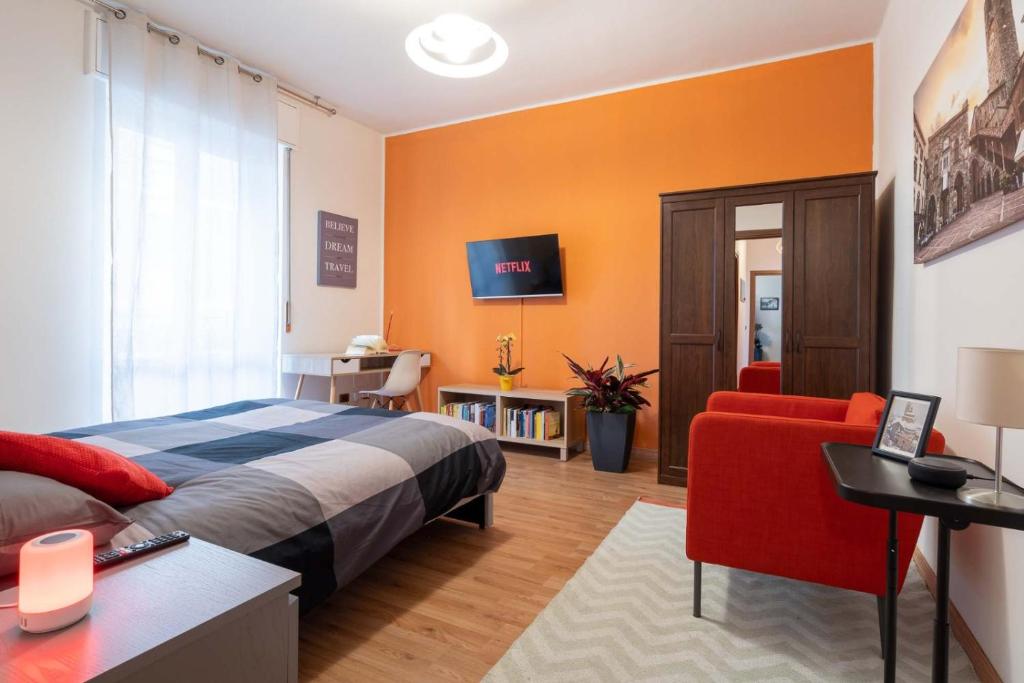 a bedroom with a bed and a red chair at Casa Martina- Airport free shuttle-H24 in Bergamo