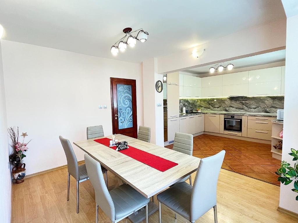 a kitchen and dining room with a wooden table and chairs at Spacious and Bright Maisonette Varna Center in Varna City