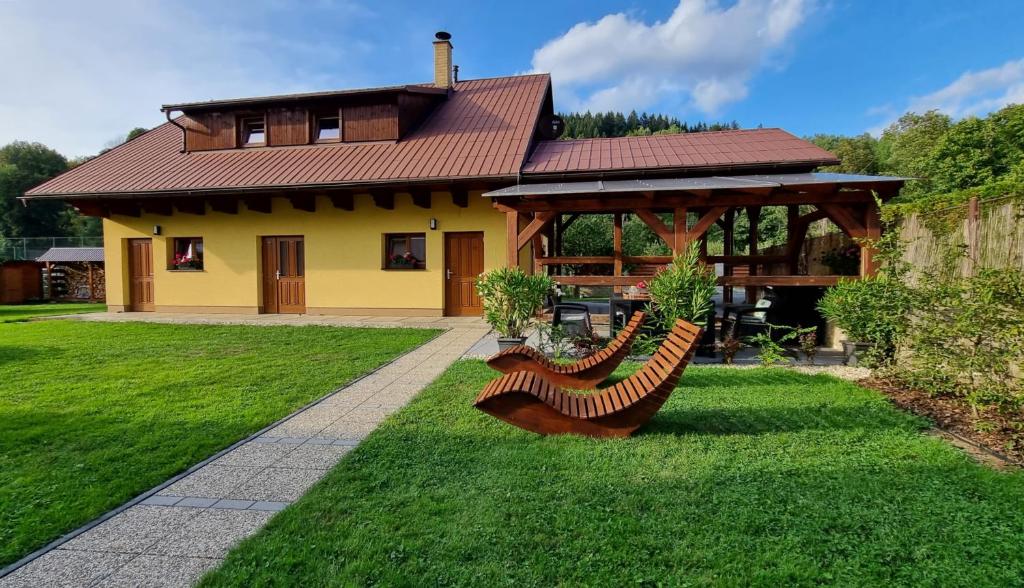 een huis met een tuinhuisje en banken in een tuin bij Chalupa Staré polesí in Karolinka