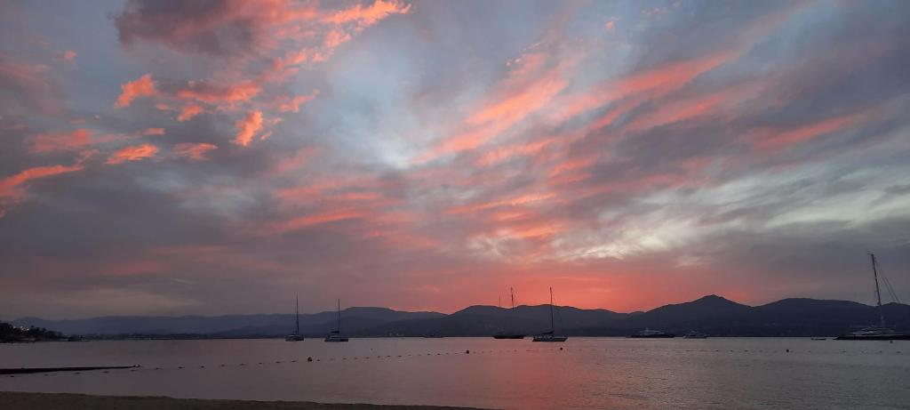 a cloudy sky with boats in the water at sunset at Villa Playa del Sol -B4 in Saint-Tropez