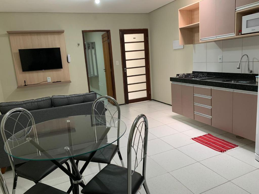 a kitchen with a glass table and a couch at Residencial Milagre 202 in Juazeiro do Norte