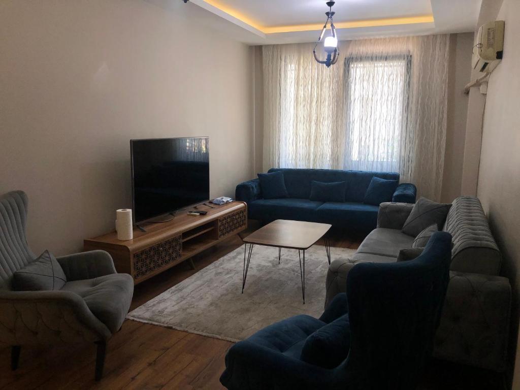 伊斯坦堡的住宿－Alsama Apart No 88，客厅配有蓝色的沙发和平面电视。