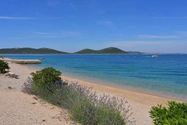 una playa con agua azul y montañas de fondo en Eden Lady Mobile Home, Croatia, Drage, en Drage