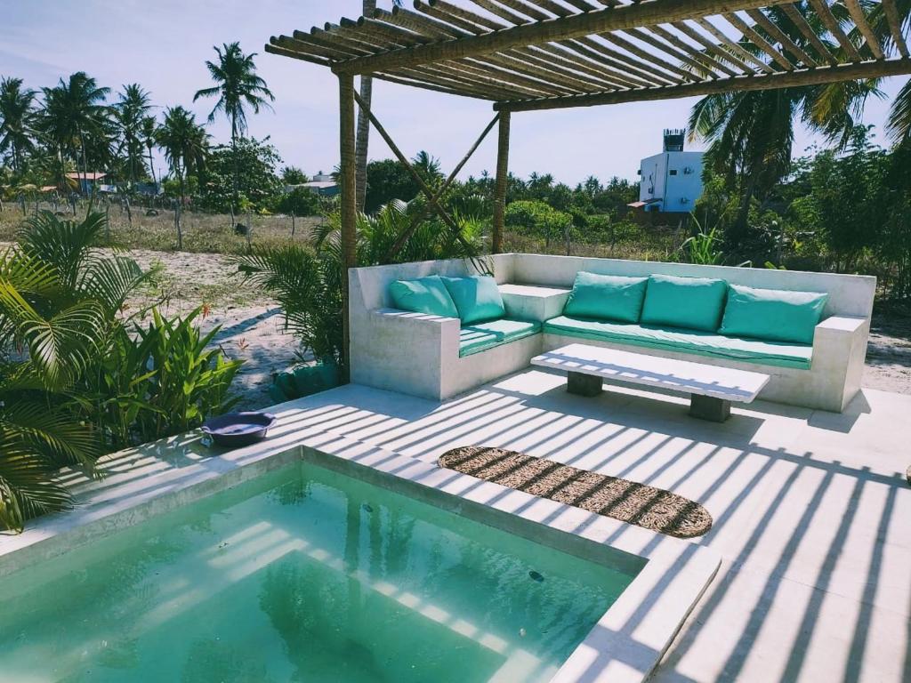 une terrasse avec un canapé et une piscine dans l'établissement La Mangrove - Casa com piscina na Praia do Preá, à Prea