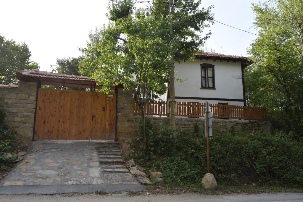 uma casa com um portão de madeira e uma cerca em Тихия кът em Malchovtsi