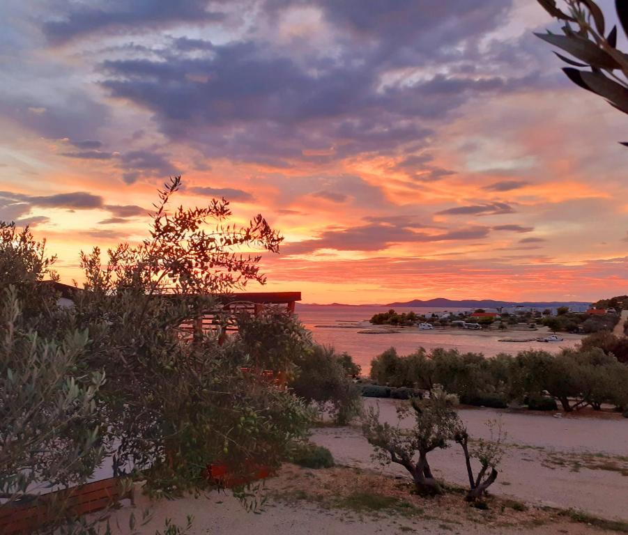 a sunset in the desert with a building in the distance at Eden Lady Mobile Home, Croatia, Drage in Drage