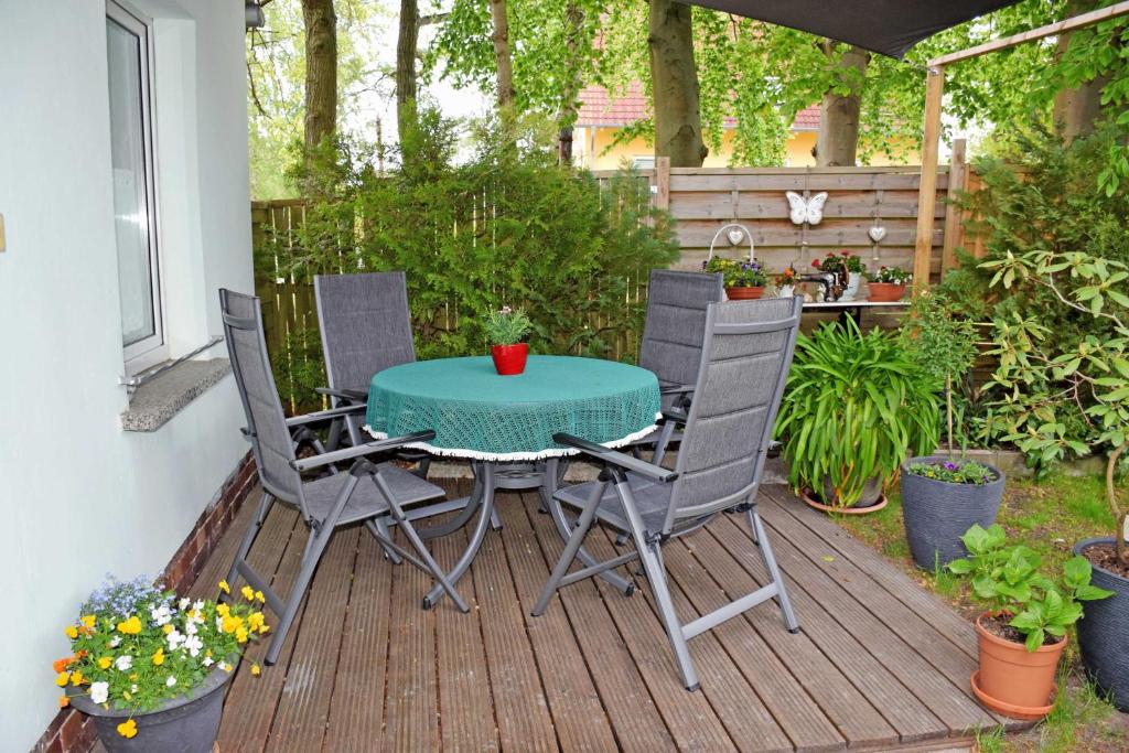 a patio with a table and chairs on a deck at Ferienhaeuser im Ostseebad Baabe in Baabe