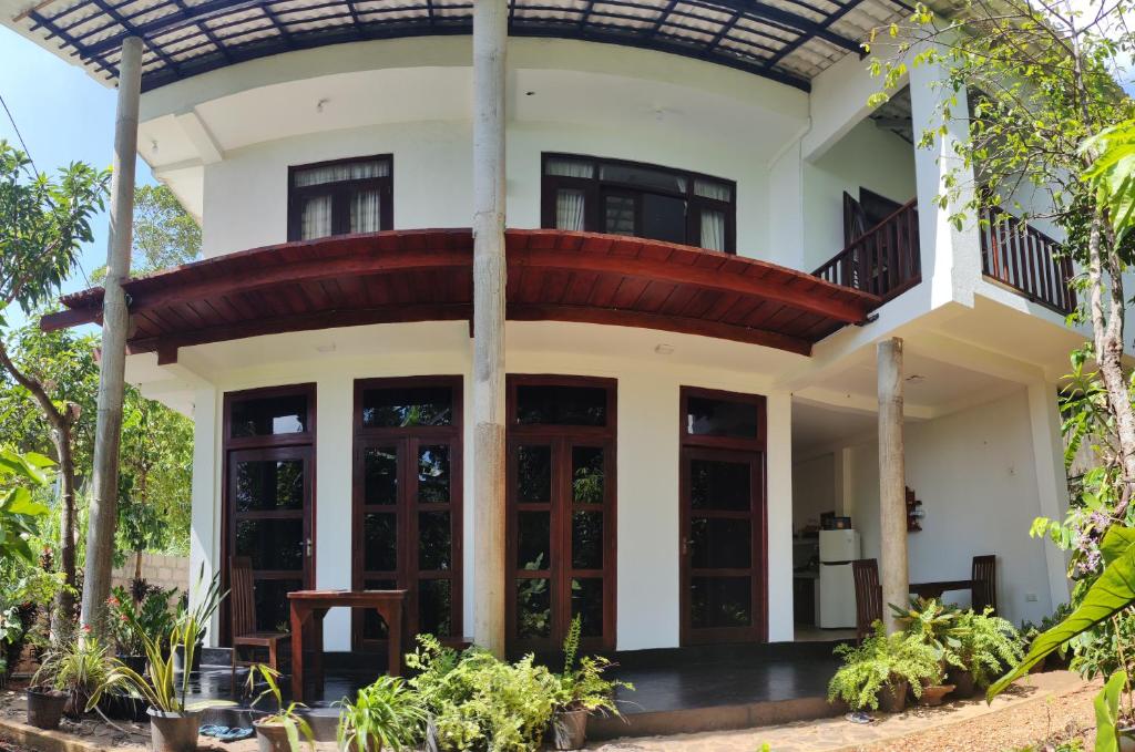 a house with a round roof and glass doors at Arazo villa in Unawatuna