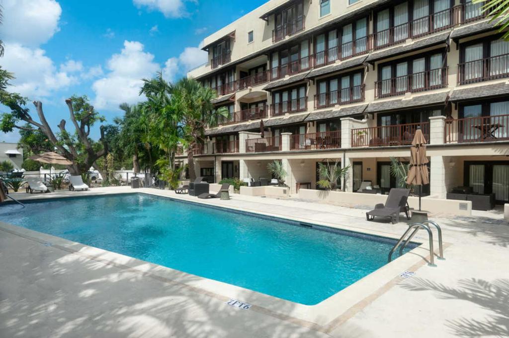 a swimming pool in front of a building at Wonderful 1-bed condo, 2min walk to beach & more in Bridgetown