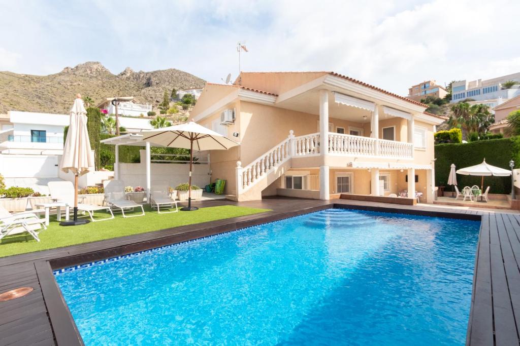 een villa met een zwembad en een huis bij Agradable casa con piscina in Bolnuevo