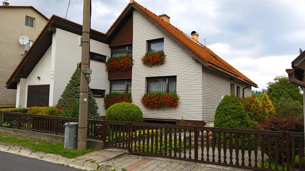 une maison blanche avec des boîtes de fleurs sur les fenêtres dans l'établissement Apartmán 6 km od centra Banskej Bystrice, à Banská Bystrica