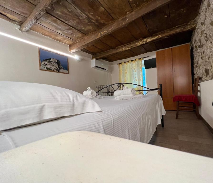 トロペアにあるA casa di Alessandro Appartment'sのベッドルーム1室(白いシーツが備わるベッド2台付)