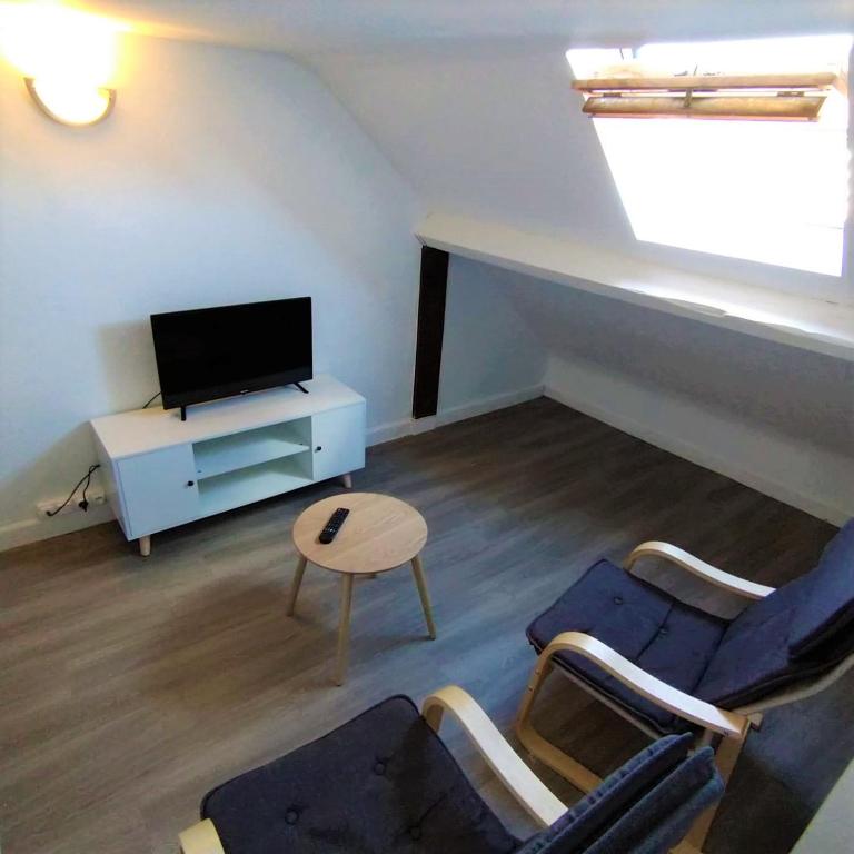 a living room with a tv and two chairs and a table at Halles Brauhauban Tarbes - T6 en collocation - Louez votre chambre in Tarbes