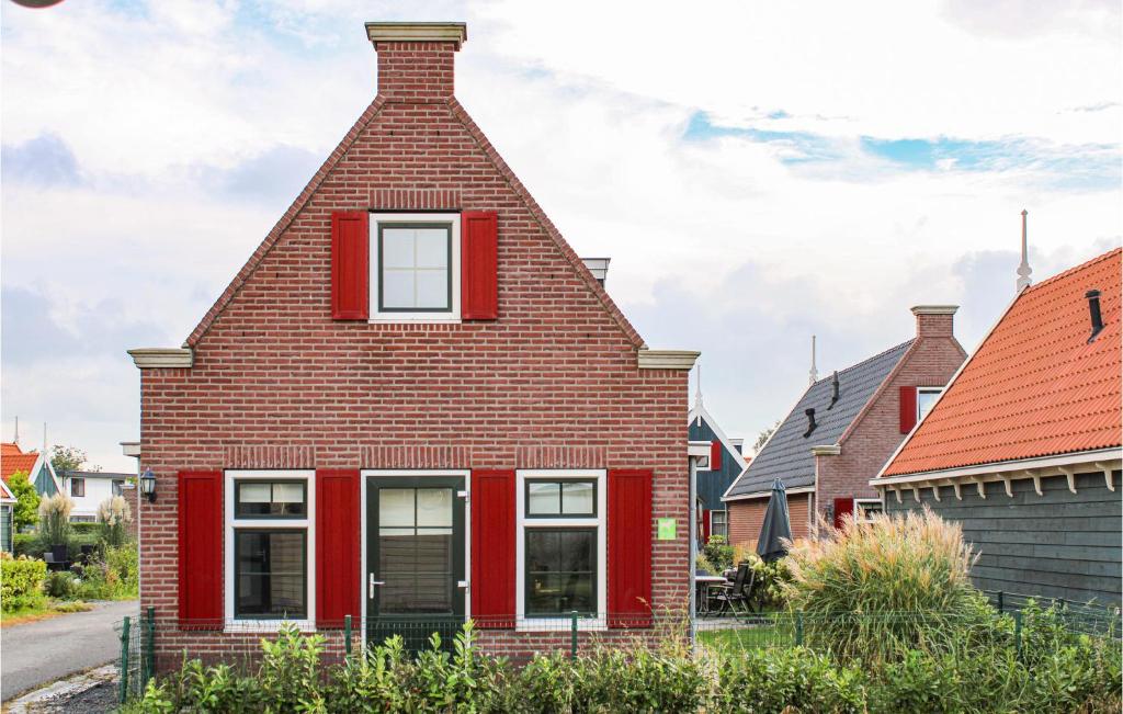 una casa roja con techo de gambrel en Awesome Home In West-graftdijk With Kitchen, en West-Graftdijk