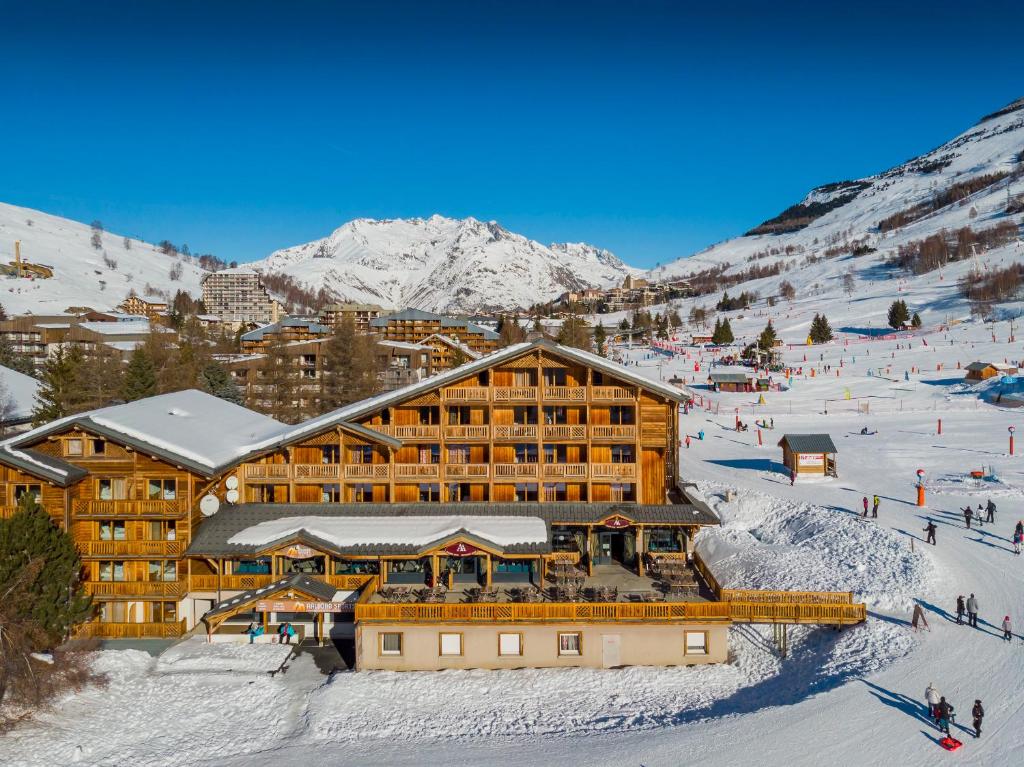 un lodge de ski dans les montagnes enneigées dans l'établissement Hôtel Aalborg, à Les Deux Alpes