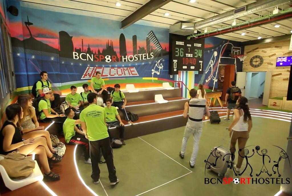 a group of people standing around in a room with a show at BcnSportHostels in Barcelona