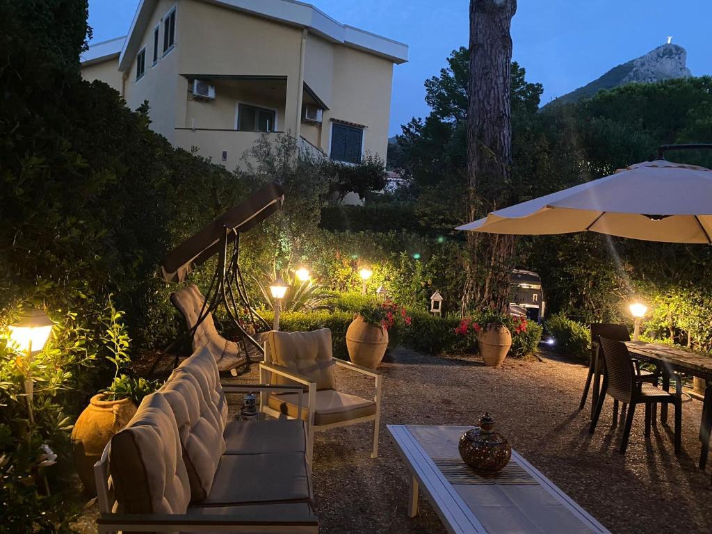 een patio met stoelen, een tafel en een parasol bij DavEli House in Maratea