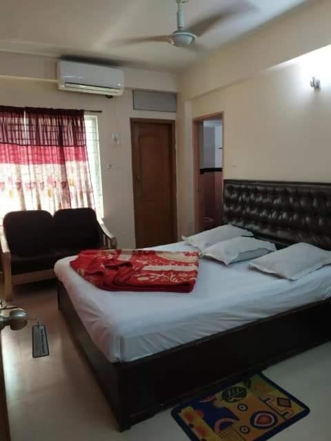 a bedroom with a bed with a red blanket on it at Sea Breeze Resort in Cox's Bazar