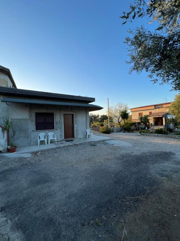 a house with two white chairs in front of it at La casa di Peppe in Monasterace