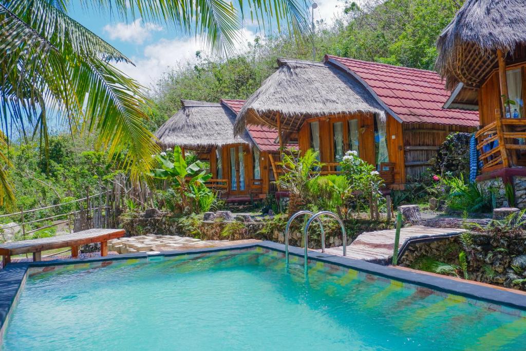 a villa with a swimming pool and a resort at The Tamban Jukung in Nusa Penida