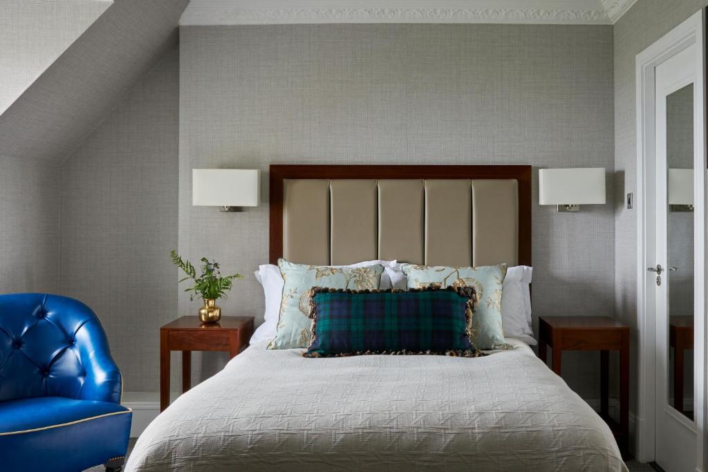 um quarto com uma cama e uma cadeira azul em Marine Troon em Troon