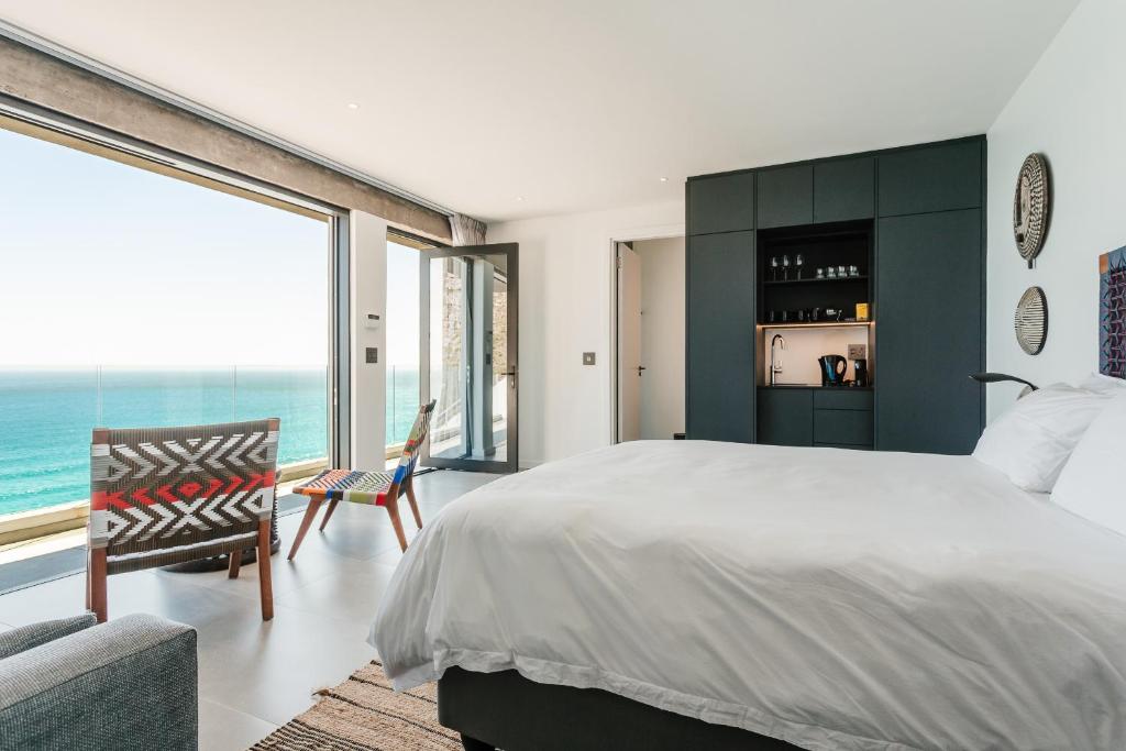 a bedroom with a large bed and a large window at Beyond Misty Cliffs in Scarborough