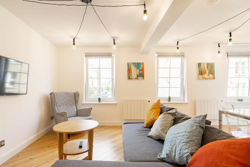 a living room with a couch and a table at Central, Bright 2 Bed Flat - Pool & Sauna in Edinburgh