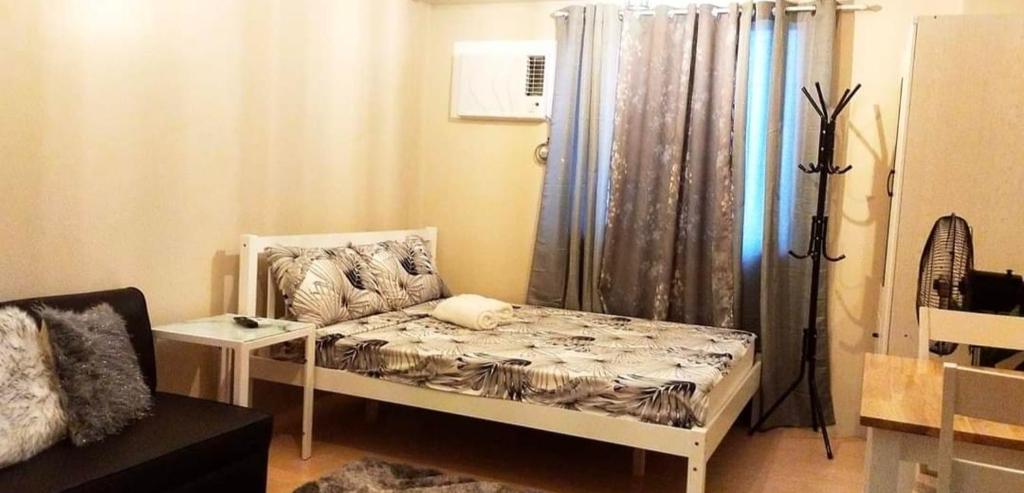 Cette petite chambre comprend un lit et un rideau. dans l'établissement SunVida Tower, à Cebu