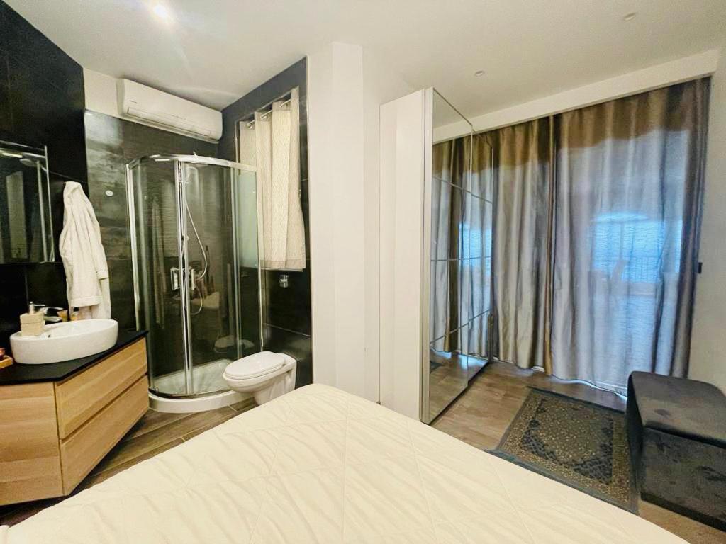 uma casa de banho com um chuveiro, um WC e um lavatório. em Beach front High End apartment, direct sea views. em Marsalforn