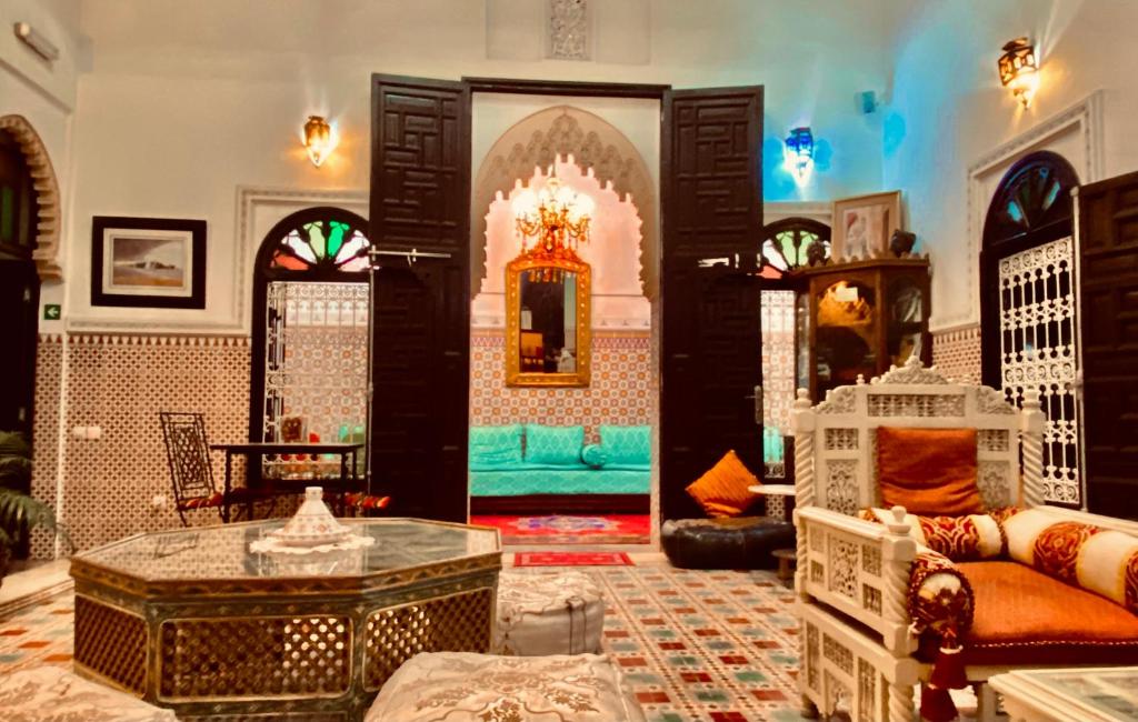 ein Wohnzimmer mit einem Sofa und einem Tisch in der Unterkunft Riad Baddi in Salé