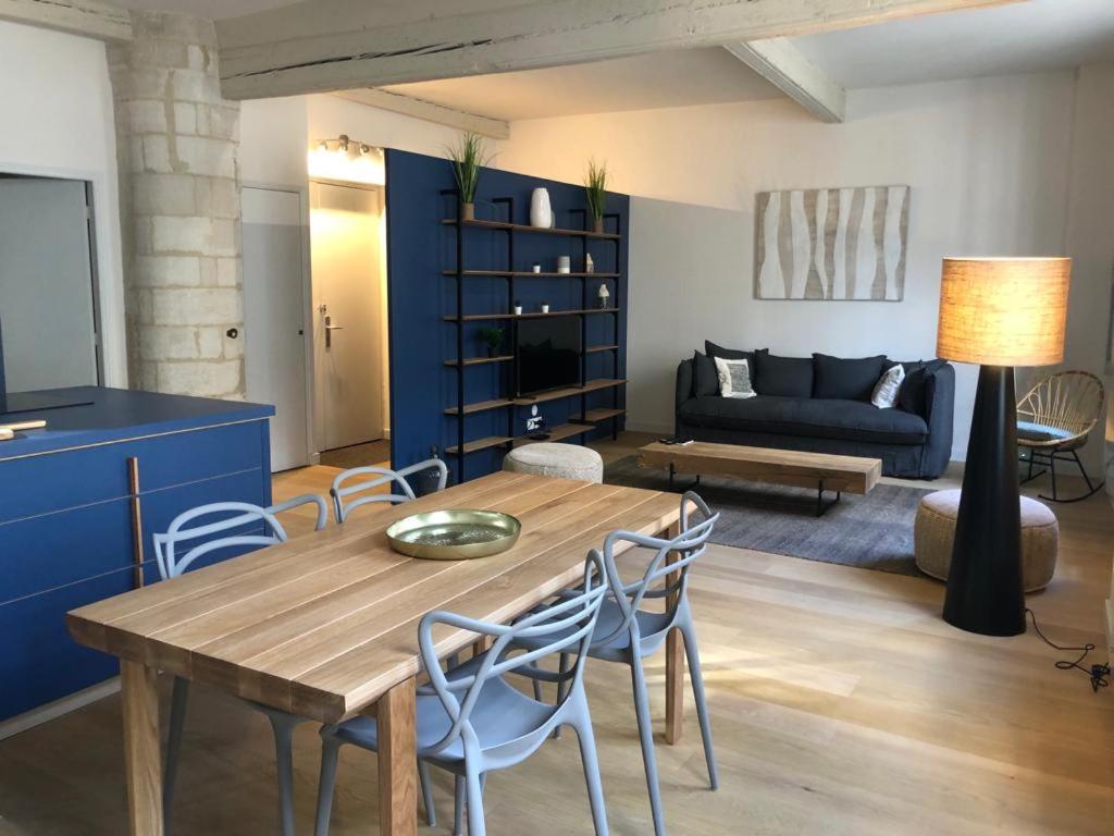 un salon avec une table et des chaises en bois dans l'établissement Appartement climatisé plein centre historique, à Avignon