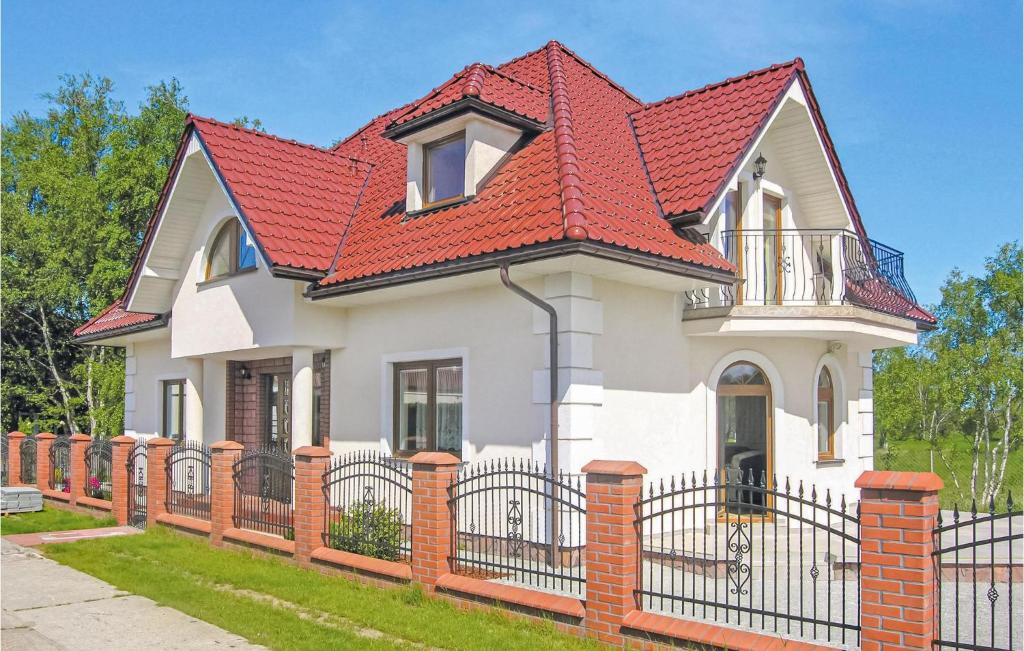 a white house with a red roof and a fence at 4 Bedroom Lovely Home In Rowy in Rowy