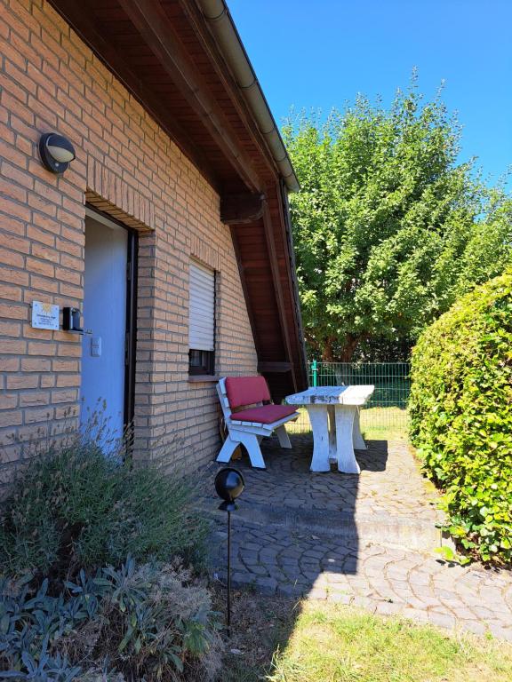 eine Terrasse mit einer Bank und einem Tisch im Hof in der Unterkunft Wohnung zum Wohlfühlen in Netphen