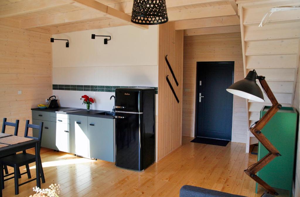 a kitchen with a black refrigerator and a table at Domek Dzikie Lisko in Lesko