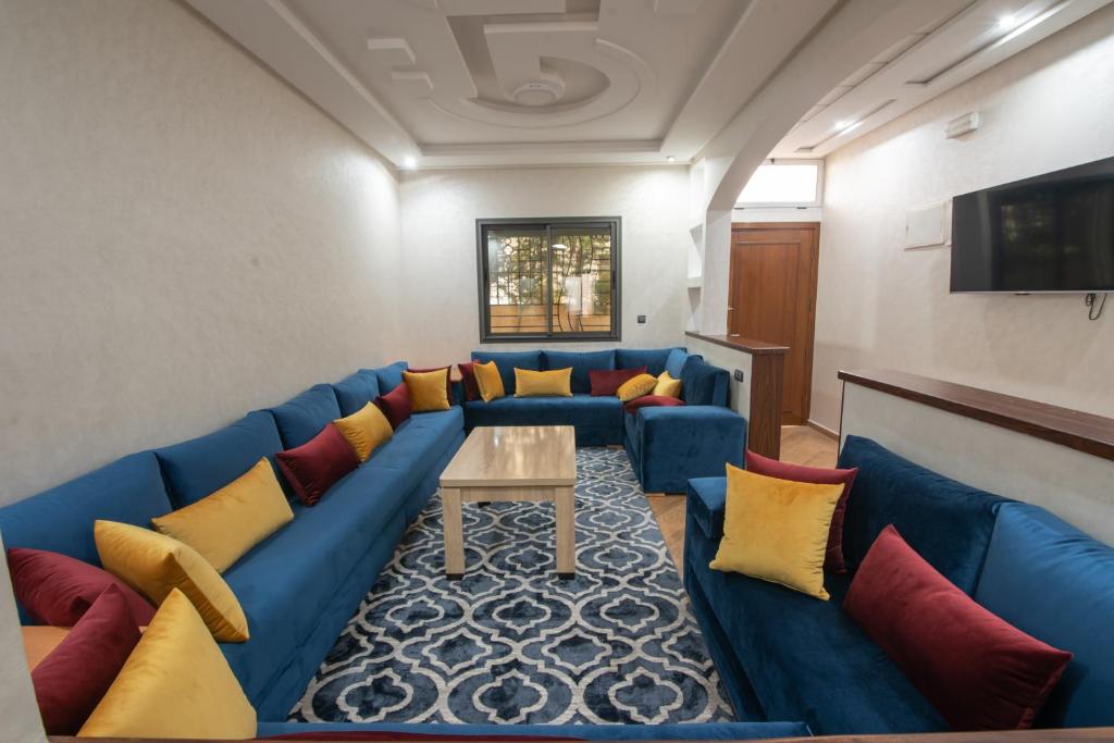 una sala de estar con sofás azules y una mesa. en Adam's Apartments,Self CheckIn 6 Mins to Beach Downtown Fiber Optic WiFi Free Parking Same Rules as Hotels en Agadir