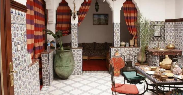 sala de estar con mesa y sofá en Riad taddert, en Marrakech