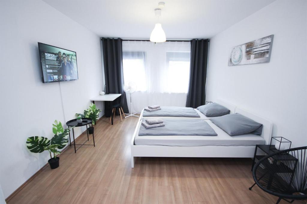 a white bedroom with a bed and a desk at ALFA Stuttgart City 4ZW Beste City Lage Berliner Platz max 8 Personen Netflix Küche WM in Stuttgart