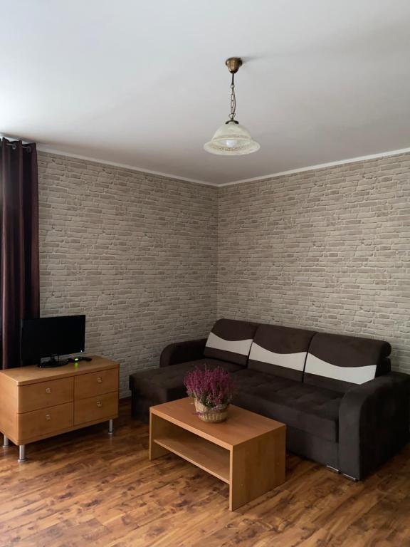 een woonkamer met een bank en een tafel bij Zajazd Kadar in Wisła
